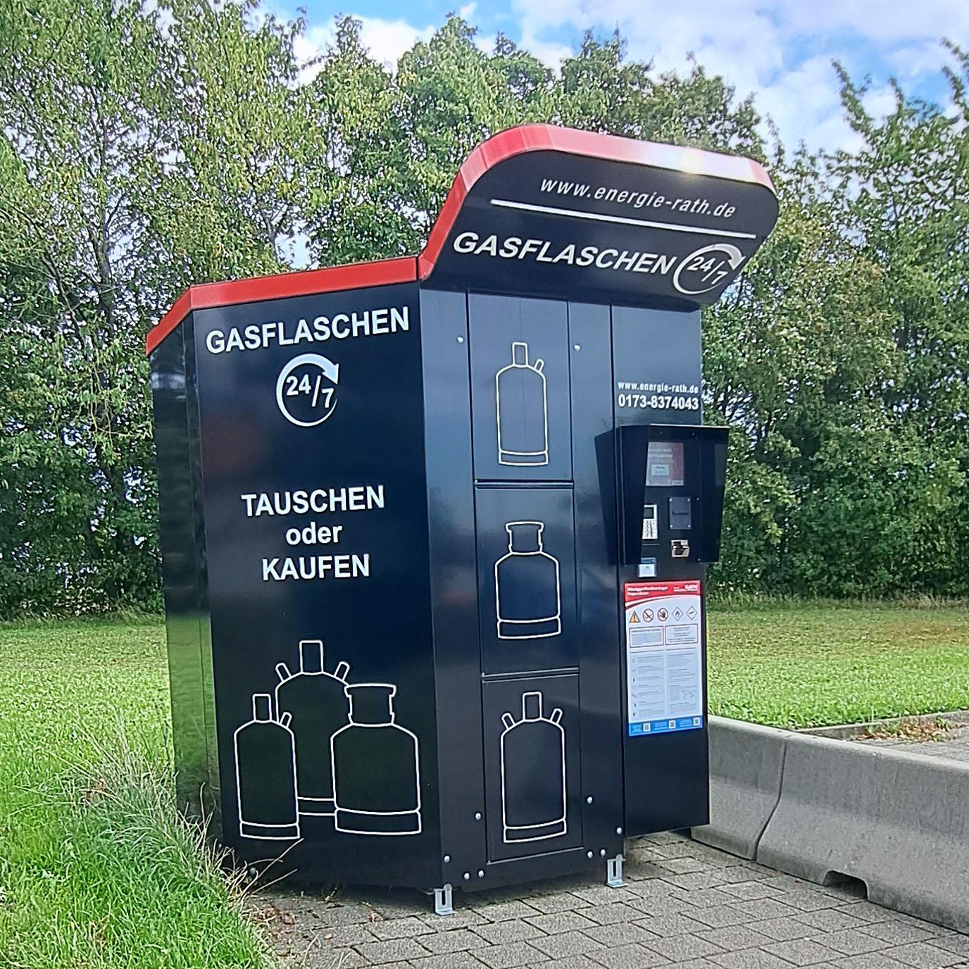 Freistehender Gasflaschenautomat auf einer Wiese neben einer Zufahrt
